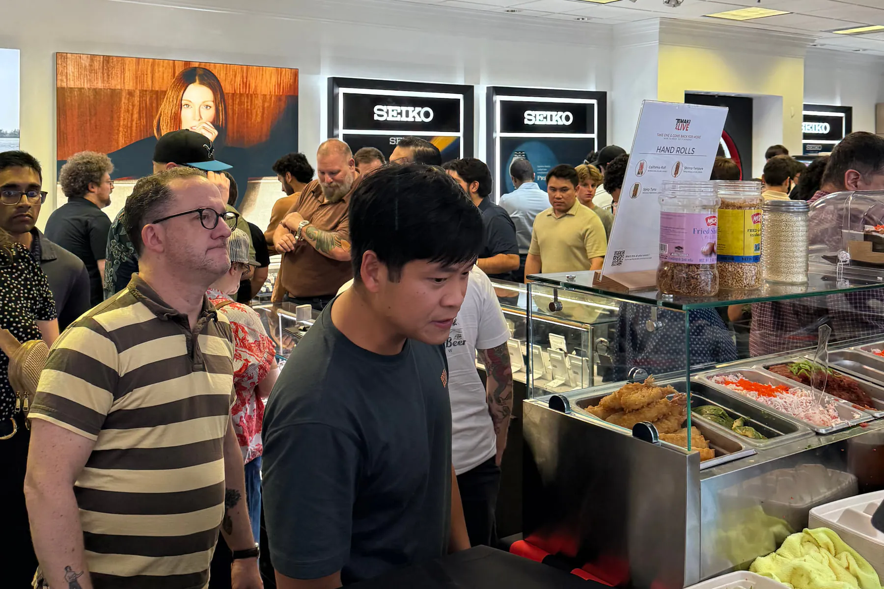 Colleagues waiting their turn at the counter while rolls are made