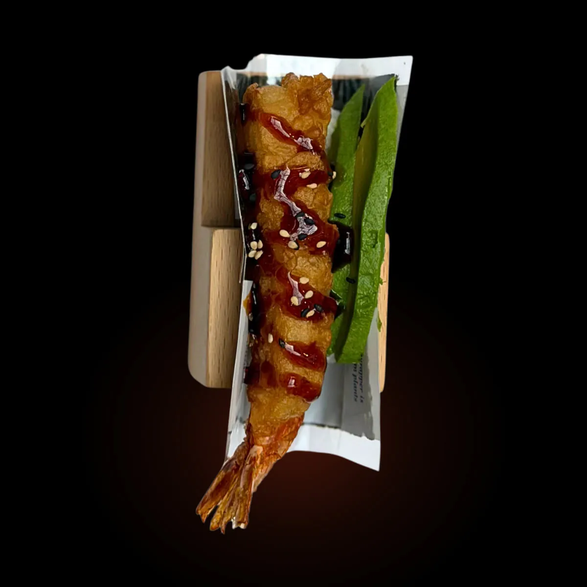 A shrimp tempura hand roll in its stand against black